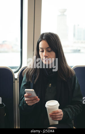 Beautiful woman using smart phone while sitting in train Stock Photo