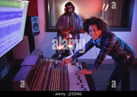 Portrait of male audio engineers using sound mixer in recording studio Stock Photo