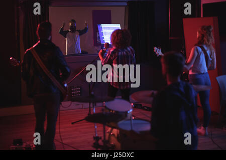 Rear view of band performing in recording studio Stock Photo