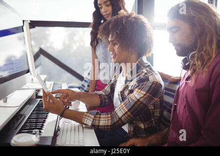 Sound engineers using digital tablet while working in studio Stock Photo