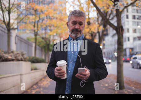 Businessman using phone while standing in city Stock Photo
