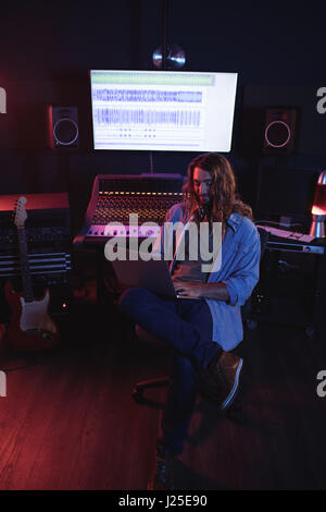 Male audio engineers using laptop in recording studio Stock Photo
