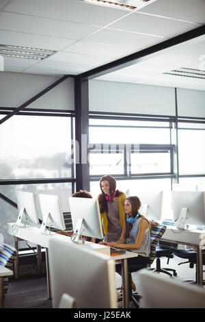 Attentive female sound engineer and colleague working in office Stock Photo
