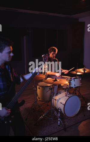 Drummer and guitarist practicing together in recording studio Stock Photo