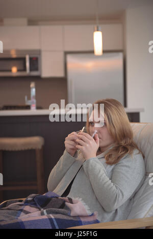 Woman drinking on sofa at home Stock Photo