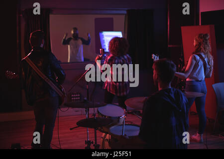 Rear view of band performing in recording studio Stock Photo