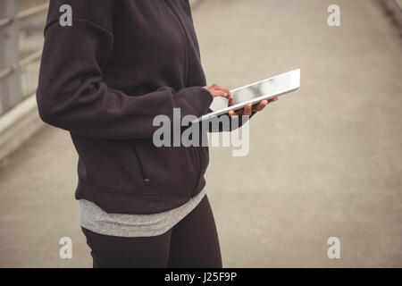 Mid section of woman using digital tablet Stock Photo