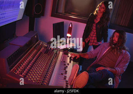 Audio engineers using sound mixer in recording studio Stock Photo