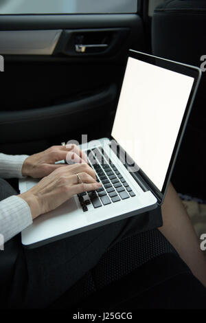 Midsection of woman using laptop while sitting in car Stock Photo