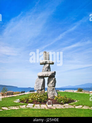 Inukshuk, symbol of the 2010 winter olympic games, with blue sky at English Bay in Vancouver, British Columbia, Canada Stock Photo