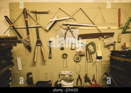 Various tools hanging on wall at beekeeping factory Stock Photo