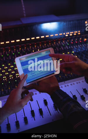 Male audio engineers using digital tablet in recording studio Stock Photo