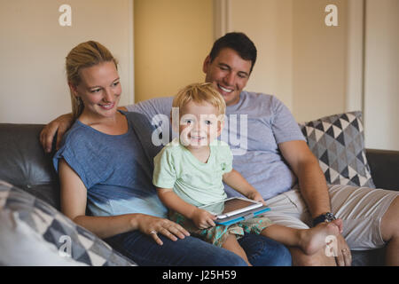 Portrait of smiling parents and son using digital tablet on sofa at home Stock Photo