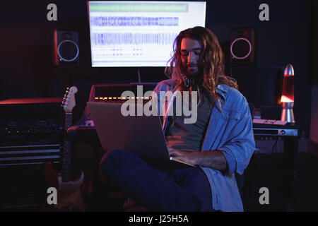 Male audio engineers using laptop in recording studio Stock Photo