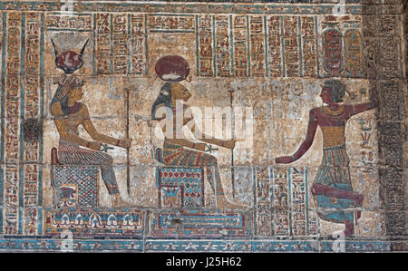 Hieroglypic colourful carving paintings on wall at the ancient egyptian temple of Khnum in Esna with god Sekhmet Stock Photo