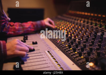 Hands of female audio engineer using sound mixer in recording studio Stock Photo
