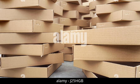 Many open blank cardboard packagings stacked on piles on a flower market table. Stock Photo
