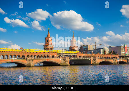 Classic panoramic view of famous Oberbaum Bridge with historic Berliner U-Bahn crossing the Spree river on a sunny day with blue sky, Berlin, Germany Stock Photo