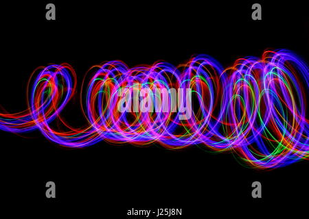 Long exposure photograph of neon multi-colour in an abstract pattern against a black background. Light painting photography, abstract colour Stock Photo