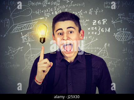 smart student with bright idea light bulb and high school maths and science formulas on blackboard background Stock Photo