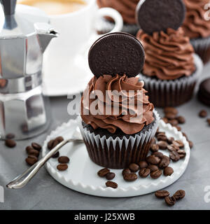 Chocolate coffee cupcakes with dark frosting decorated with sandwich cookies Stock Photo