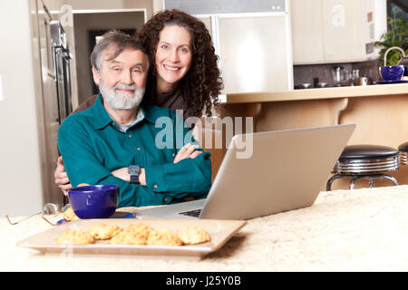 A senior father with his middle age daughter using a laptop Stock Photo