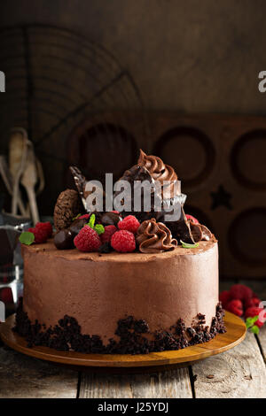 Chocolate cake with ganache frosting, festive decorations and raspberry Stock Photo