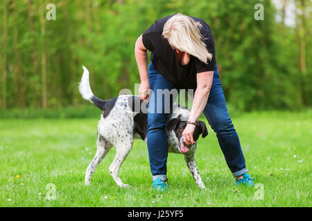 woman plays with her mixed breed dog outdoors Stock Photo