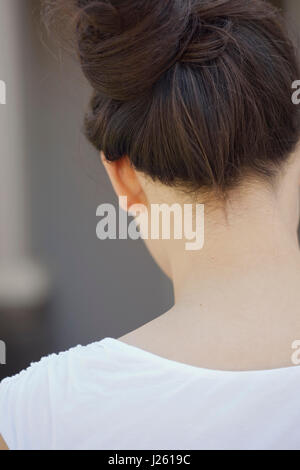 Head and Shoulders Portrait of Woman with Hair Pulled Up, Rear View Stock Photo
