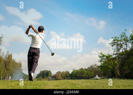 Golfer Hitting Golf Shot with Club on Beautiful Golf Course on Vacation Stock Photo