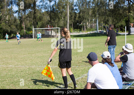 Girl female lineswoman linesman referee assistant at a male football soccer game in Sydney, between teams in the Manly Warringah league Stock Photo