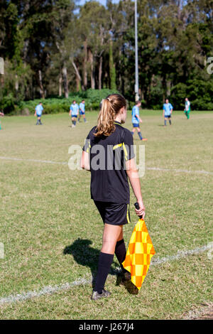 Girl female lineswoman linesman referee assistant at a male football soccer game in Sydney, between teams in the Manly Warringah league Stock Photo