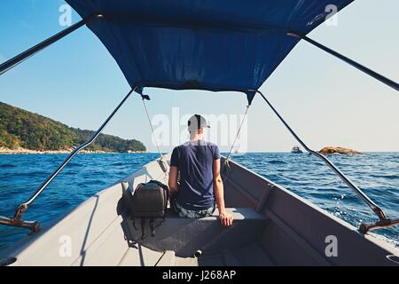 Adventure on the sea. Young man traveling by motorboat. Stock Photo