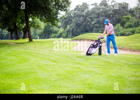Golfer selecting appropriate club for the next shot Stock Photo