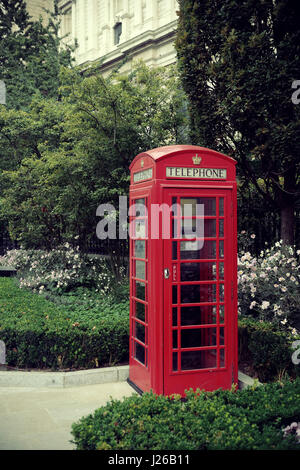 Red telephone booth in street with historical architecture in London. Stock Photo