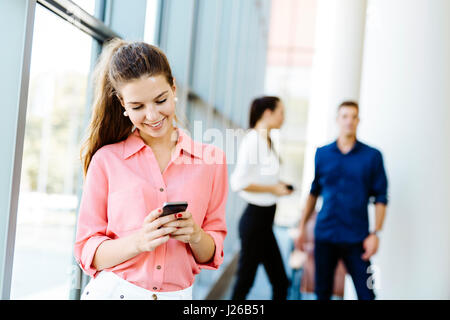 Beautiful women, colleagues using phones and talkin during break Stock Photo