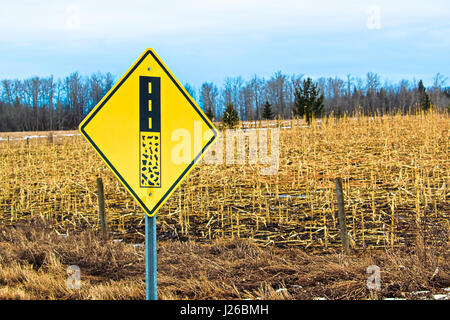 End of gravel road ahead warning sign. Stock Photo