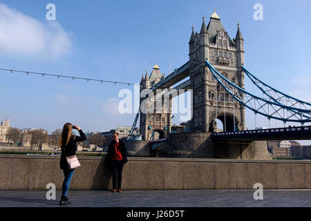 Tourist taking a picture of a friend in front of the Tower Bridge, London, England, United Kingdom, Europe Stock Photo