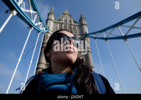Portrait of a pretty young woman wearing sunglasses on a sunny day, Tower Bridge, London, England, UK, Europe Stock Photo