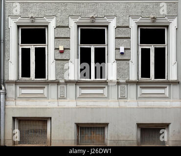 Three windows with decorative stone frames in the house stylized by a retro. Glass isolated with black Stock Photo