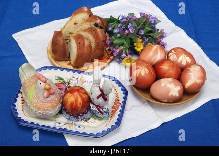 VILNIUS, LITHUANIA -APRIL 16, 2017: The easter rural composition on a table. Traditional colored eggs,  Easter cake, forest wild flowers, handmade chi Stock Photo