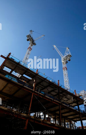 Construction cranes against a blue sky in London, England, UK Stock Photo