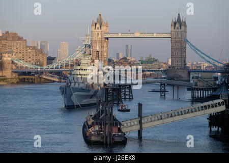 HMS Belfast warship moored on the River Thames next to the Tower Bridges, London, England, UK Stock Photo