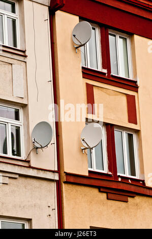three satellite dishes on the facade of a residential building Stock Photo
