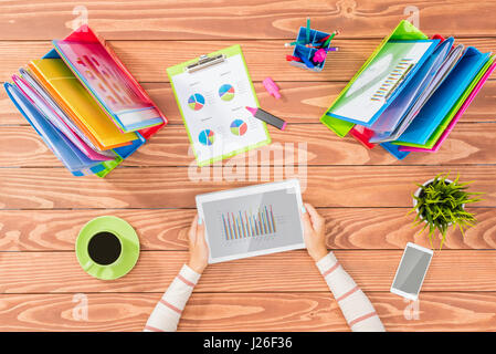 Overhead shot of woman working on tablet in office Stock Photo
