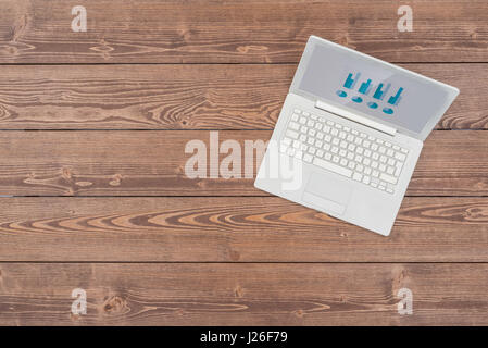 Open white laptop on wooden table Stock Photo