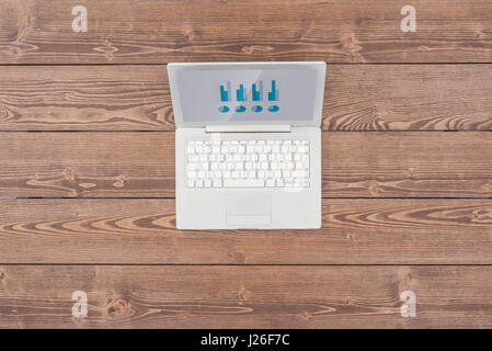 Open white laptop on wooden table Stock Photo