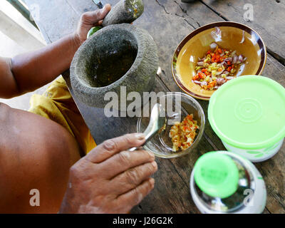 Thai fat man older cooking and seasoning spicy seafood sauce thai style in local kitchen at house in Phatthalung province of southern Thailand. Stock Photo