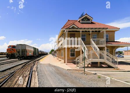 Grand Junction, USA - May 28, 2016: Freight trains on the tracks at the station with the building in front. No passengers are waiting on the platform. Stock Photo