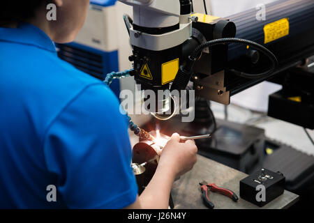 Worker welding repair mold and die part by Laser welding machine in factory. Stock Photo